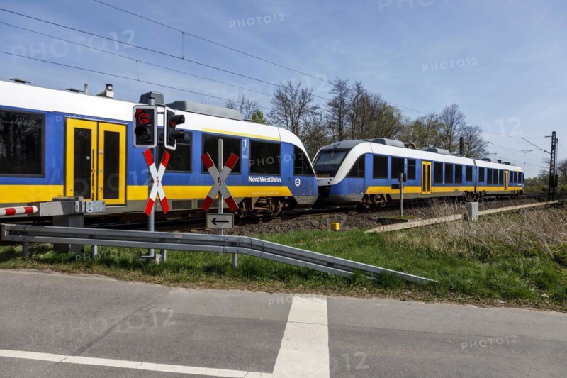 NordWestBahn passes through a level crossing with barriers
