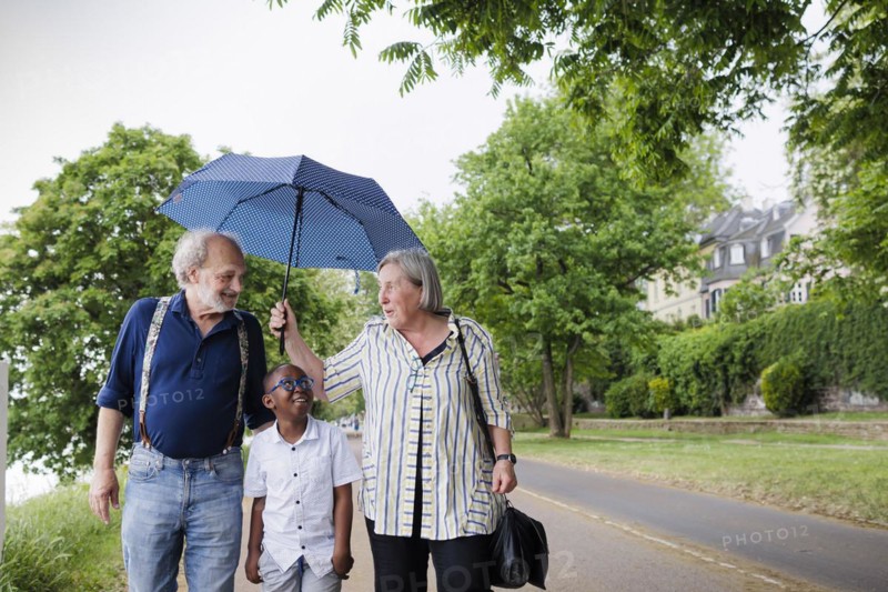 Temporary grandparents. Elderly couple volunteer to look after a boy from Africa for a few hours a week.
