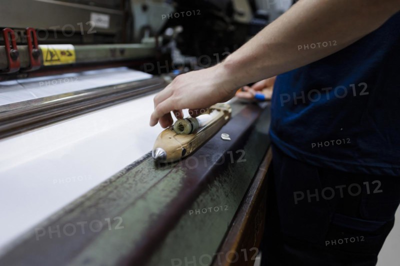 Inserting a spool of yarn into a shuttle in a weaving mill in the Allgaeu.