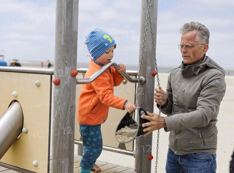 Man playing with a child on the beach