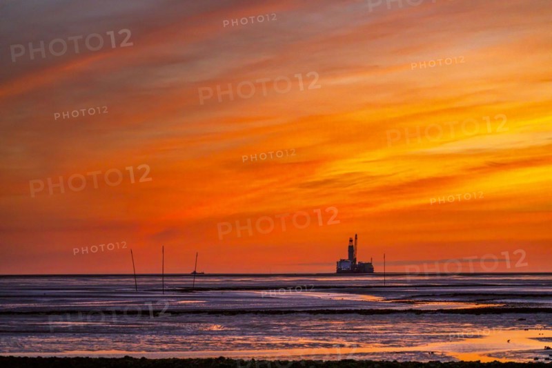 View from the Trischendamm to Germanys only drilling platform Mittelplate after sunset at low tide