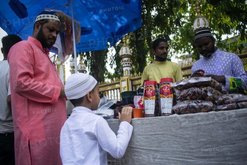 Indian Muslim father buys cap for his son before perform the second Friday prayer in the holy month of Ramadan at a Mosque in Guwahati