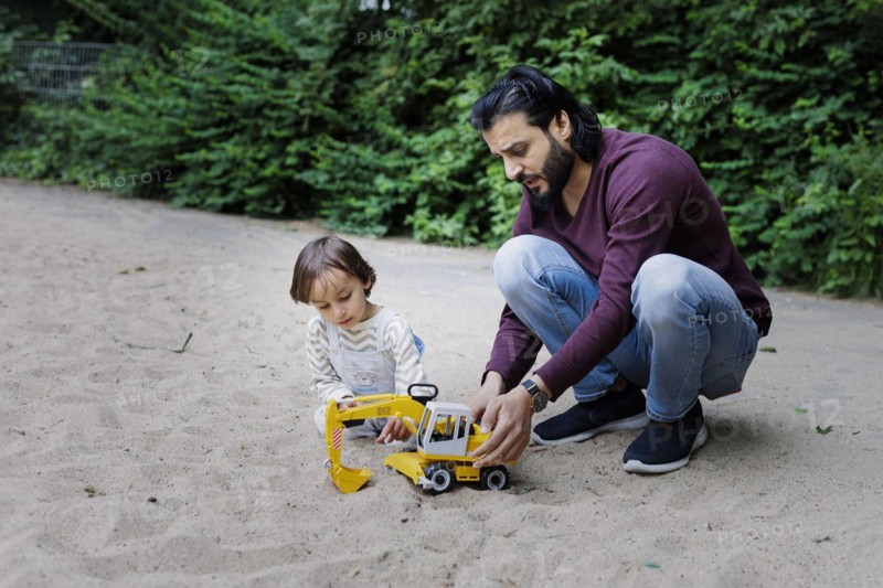 Father with child on a playground in the green