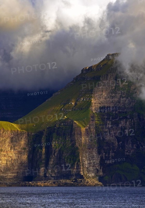 The Faroe Island of Kalsoy in the Atlantic Ocean with Sun and Clouds