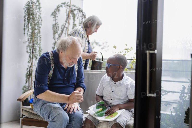 Temporary grandparents. Grandfather volunteers to look after a boy from Africa for a few hours a week.