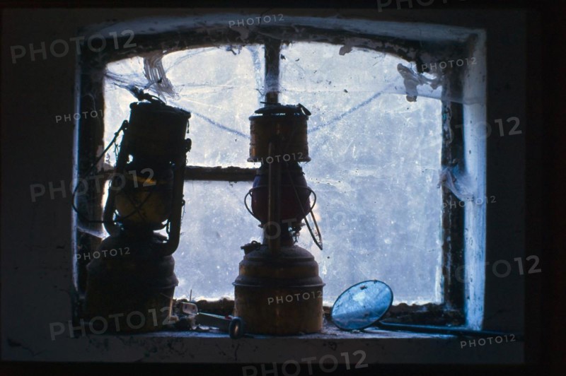 Two old stable lanterns in front of a cellar window