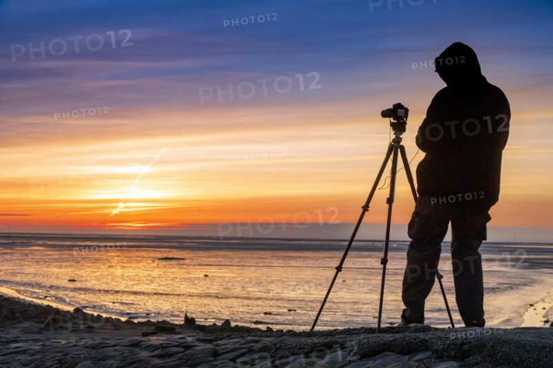 Tourist with camera during sunset on the Trischendamm