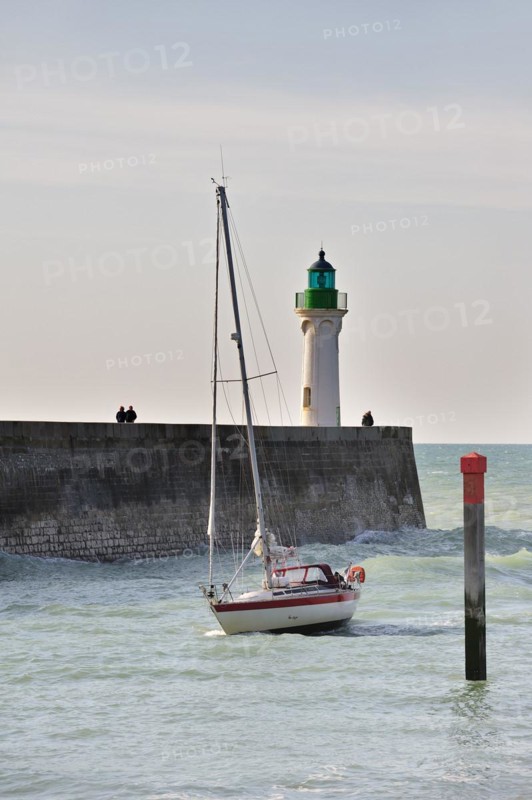 Lighthouse and sailing boat entering the harbour of Saint-Valery-en-Caux