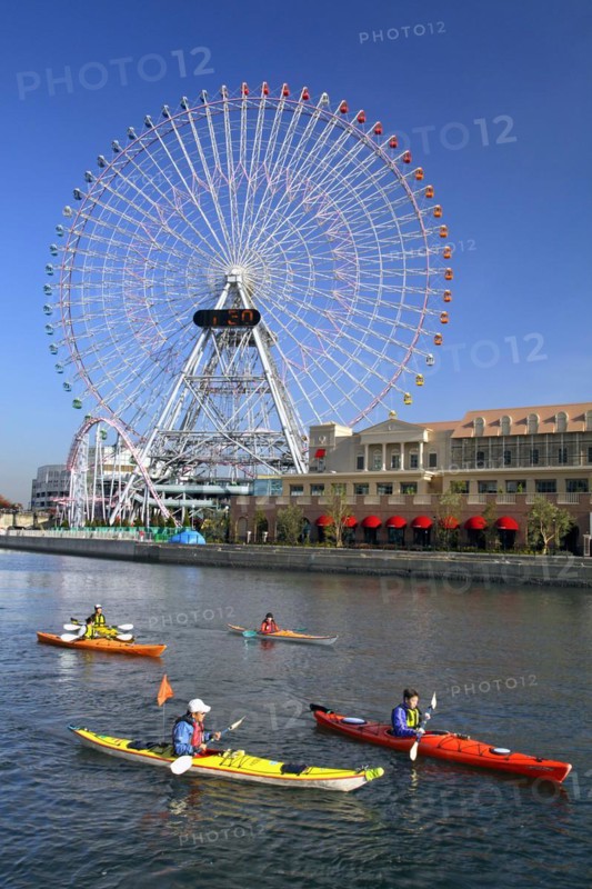 Group of kayaks on excursion and Ferris Wheel Cosmo Clock 21 of Yokohama Cosmo World in background Yokohama city Kanagawa Japan