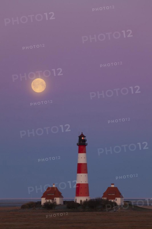 Lighthouse Westerheversand at sunset with full moon at Westerhever
