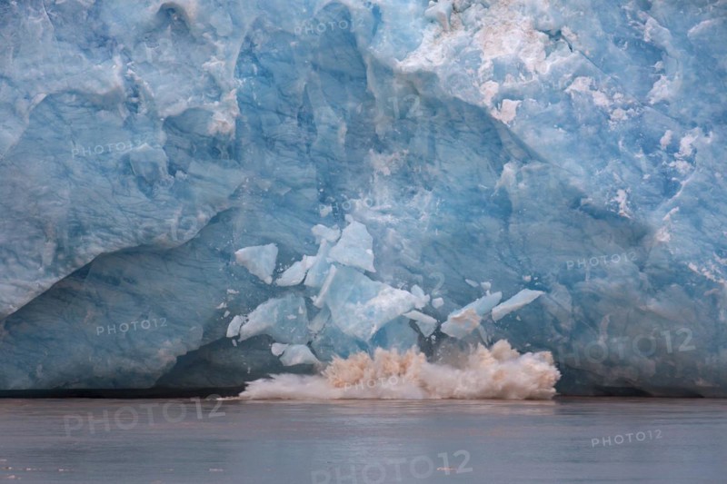 Huge ice chunk breaking from the edge of the Kongsbreen glacier calving into Kongsfjorden