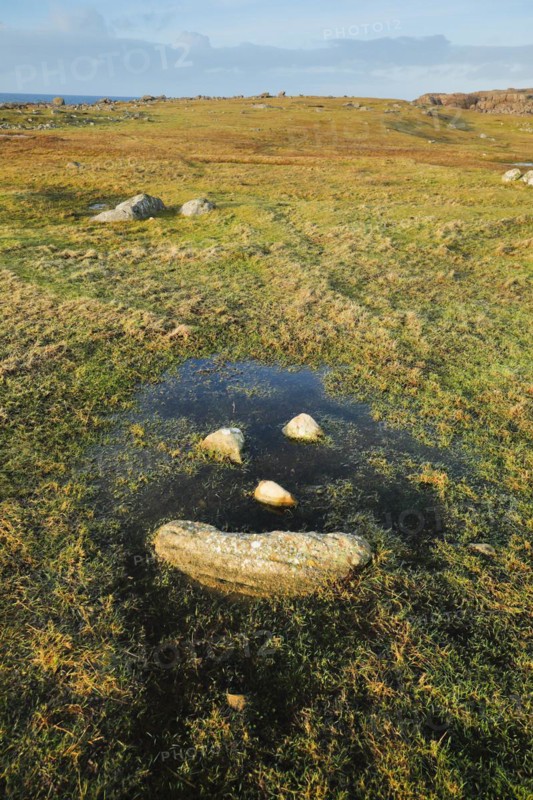 Natural smiley made of stones in the middle of a puddle of water in a meadow in the Highlands of Scotland