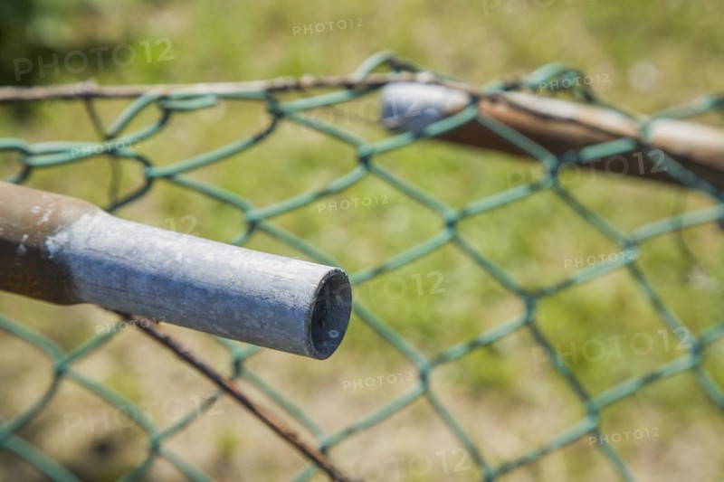 Broken railing on a chainlink fence