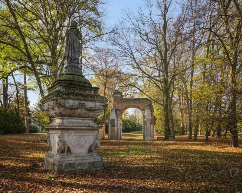Sculpture The Veiled Image of Sais and Roman Ruin Arch in the Luisium Park in Autumn