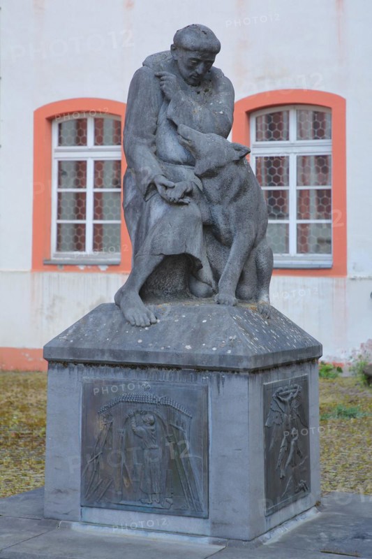 Monument with relief and sculpture of St. Francis with wolf figure at the former Jesuit monastery
