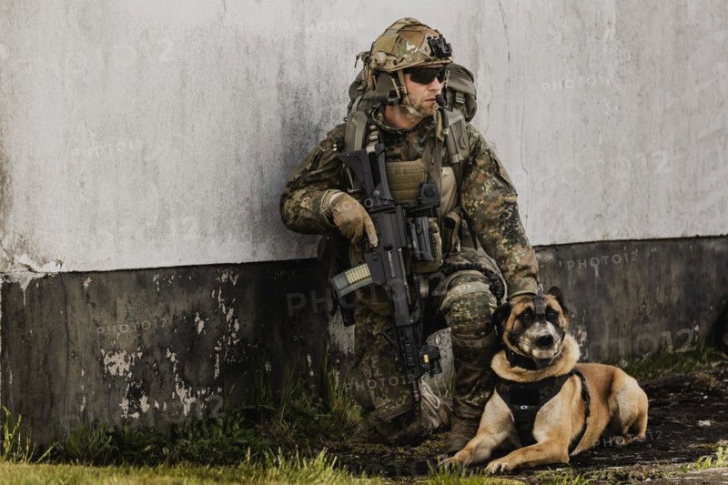 A soldier of the German Armed Forces with a mission dog
