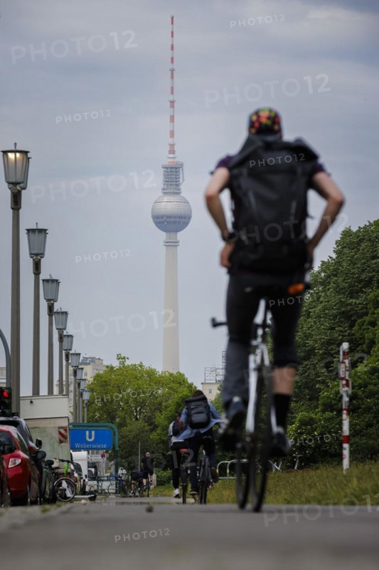 Cyclists ride along Karl Marx Allee on a cycle path towards Mitte. The television tower can be seen in the background. Berlin