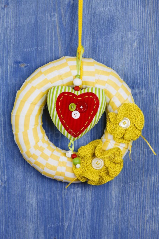 Decorative wreath on blue background and fabric heart