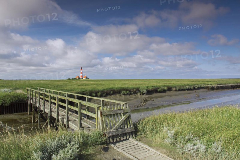 Wooden footbridge and lighthouse Westerheversand at Westerhever
