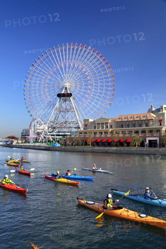 Group of kayaks on excursion and Ferris Wheel Cosmo Clock 21 of Yokohama Cosmo World in background Yokohama city Kanagawa Japan