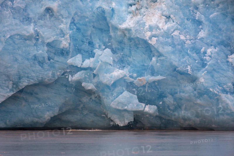 Huge ice chunk breaking from the edge of the Kongsbreen glacier calving into Kongsfjorden