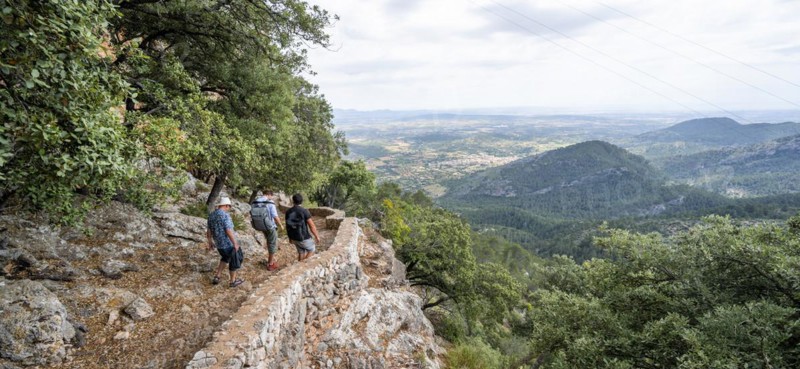 Hikers on the trail to the castle ruins of Castell Alaro