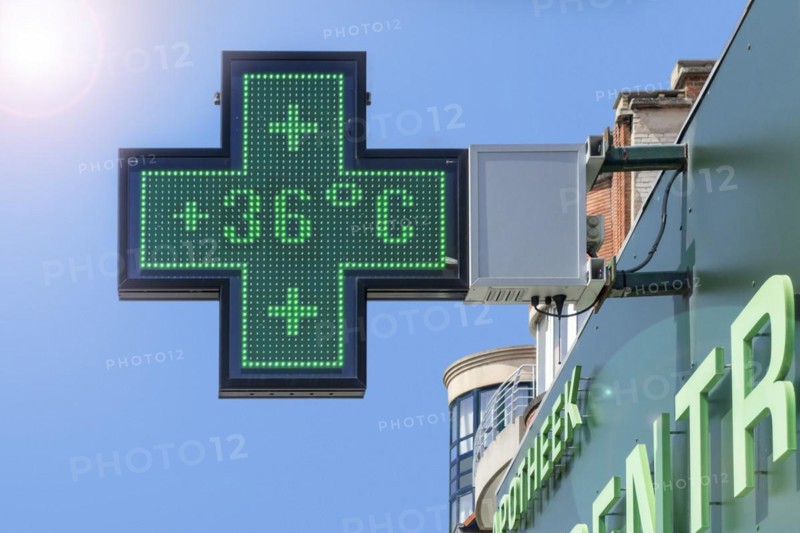 Thermometer in green pharmacy screen sign displays extremely hot temperature of 36 degrees Celsius during heatwave