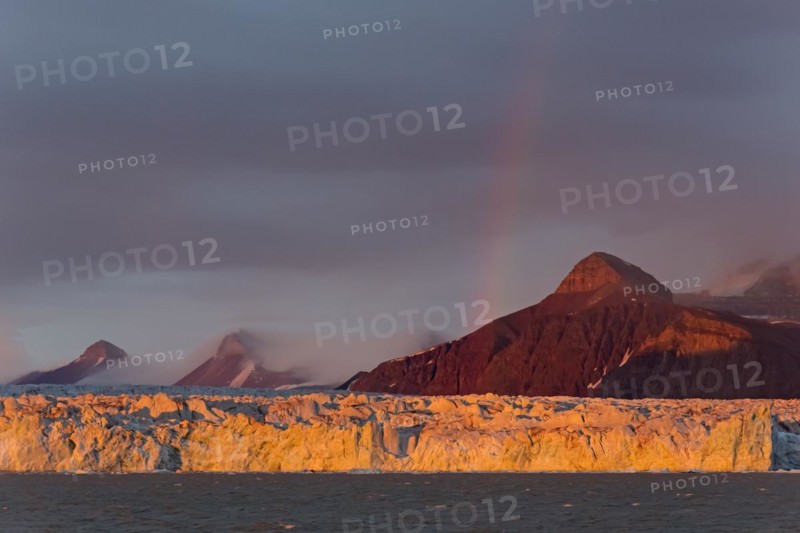 Rainbow over the Kongsbreen glacier in evening light at sunset
