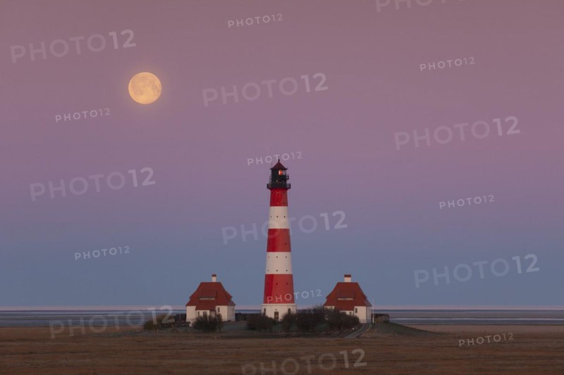 Lighthouse Westerheversand at sunset with full moon at Westerhever