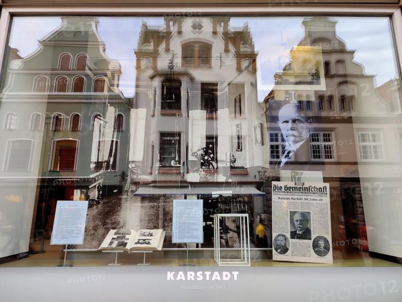 View into the shop window with reflections of gabled houses