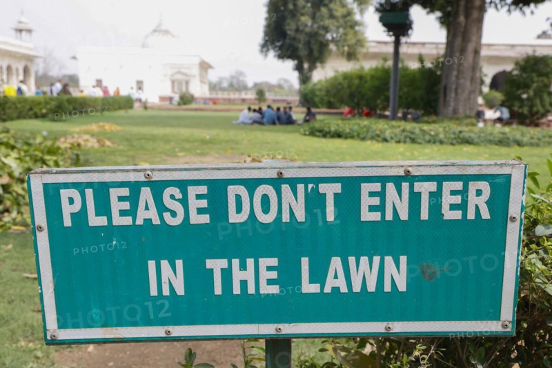 Tourists ignore the sign and picnic on the lawn