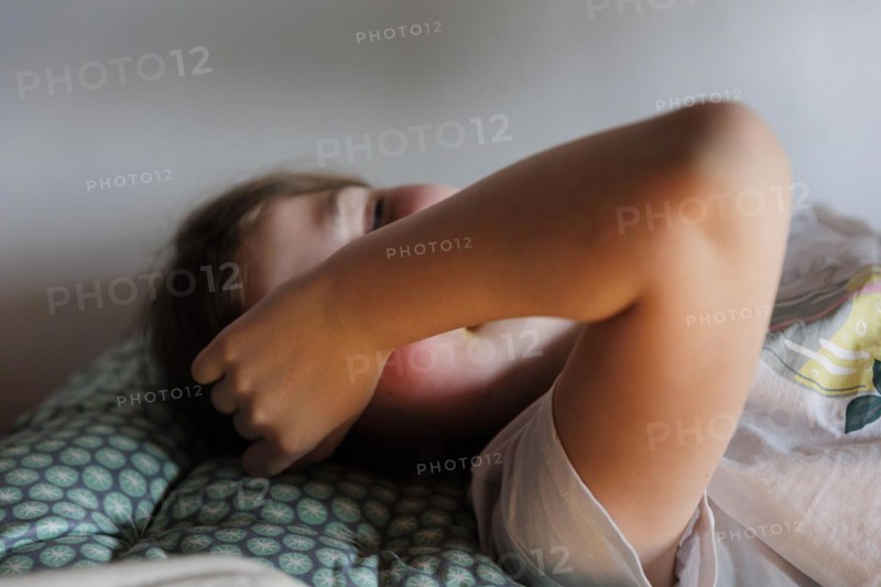 Child lying on the bed daydreaming