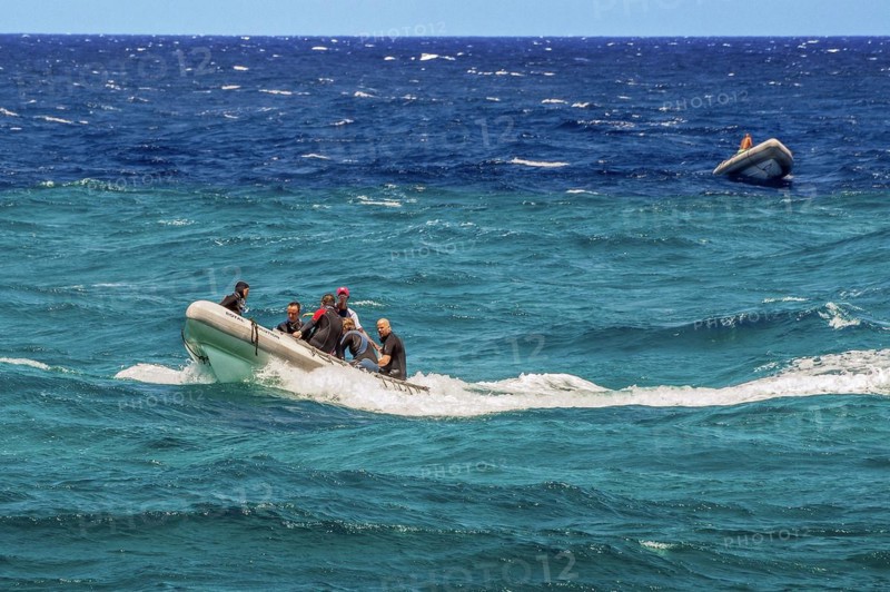 Rubber dinghies with divers in turquoise and blue water on Sanganeb Reef