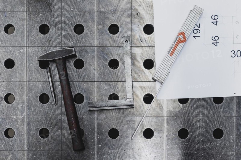 Tools and a technical drawing lying on a workbench
