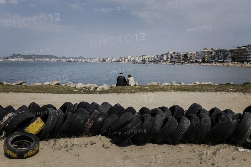 An elderly couple sitting on the beach of Durres