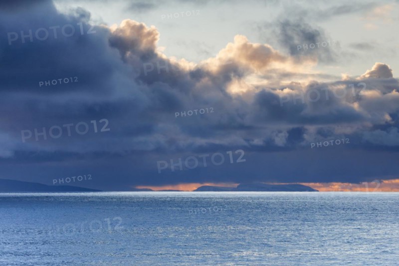 Low-lying rain clouds drift over the Summer Isles and the open waters of the blue Atlantic