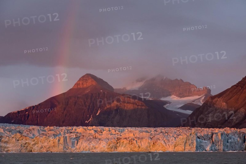 Rainbow over the Kongsbreen glacier in evening light at sunset