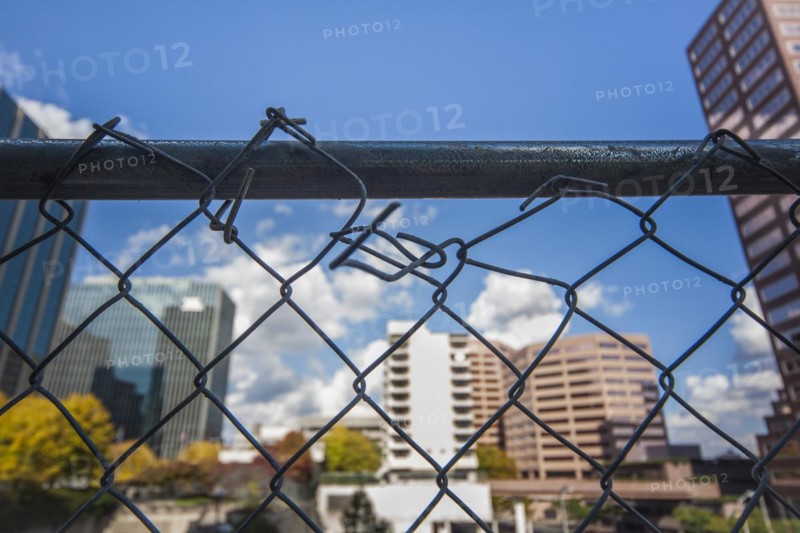 Broken chain-link fence in front of office buildings