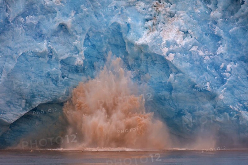 Huge ice chunk breaking from the edge of the Kongsbreen glacier calving into Kongsfjorden