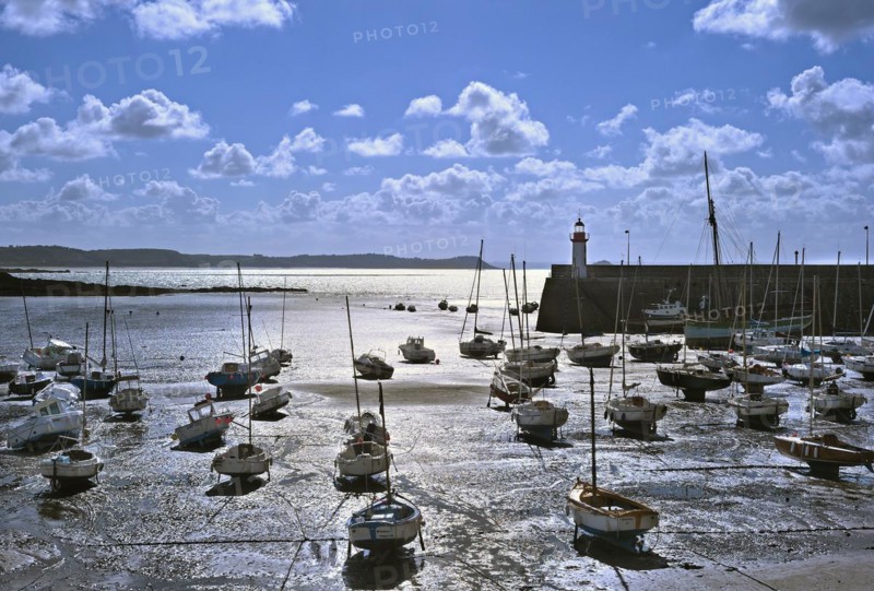 Sailing boats in the harbour of Erquy at sunset at low tide