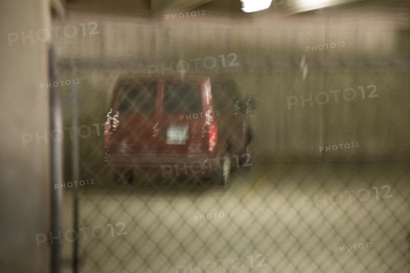 Automobile behind a fence in a parking lot
