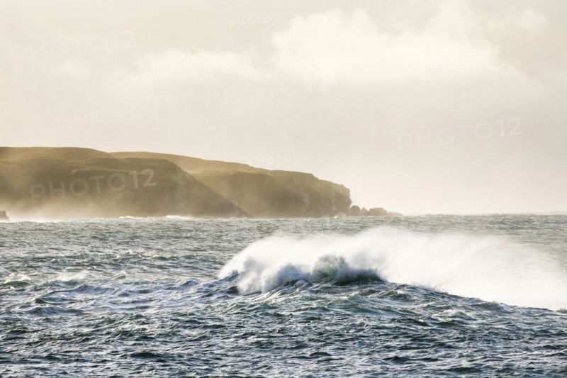 Atmospheric coastal landscape with Summer Isles at sunrise with stormy waves on open sea
