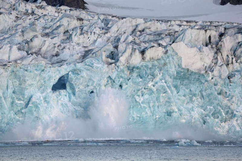 Large chunk of ice breaking off glacier and tumbling in the Magdalenefjord on Svalbard