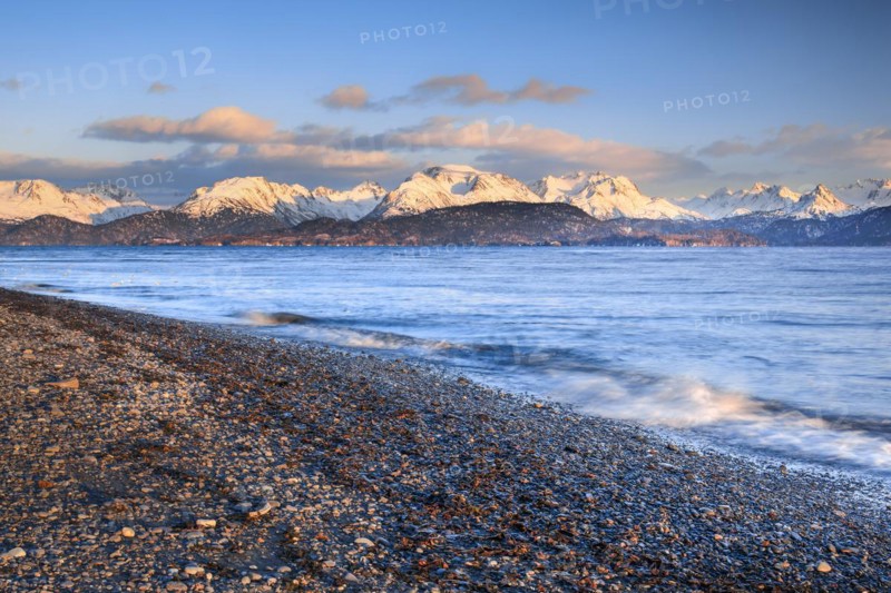 Evening atmosphere at Homer Spit with view over the stone beach and Kachemak Bay to the Kenai Mountains in the warm evening light in the background