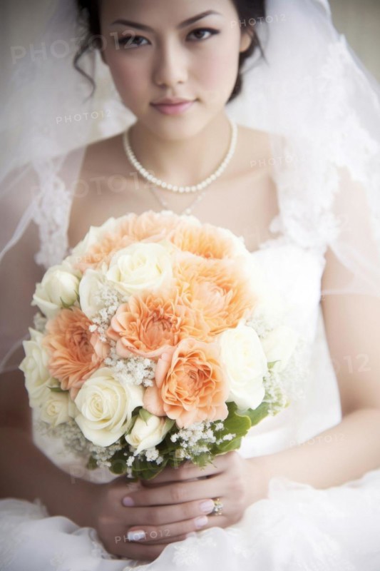 A bride in a white wedding dress holds a beautiful bridal bouquet
