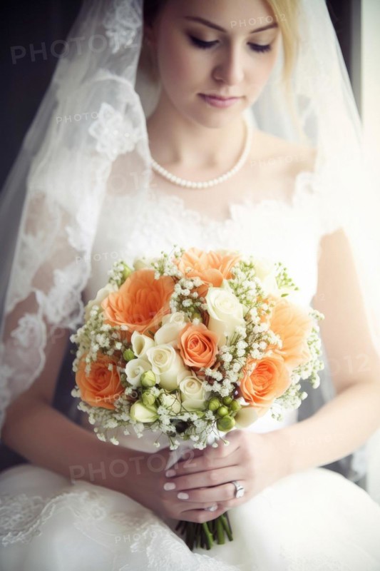 A bride in a white wedding dress holds a beautiful bridal bouquet