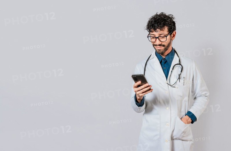 Smiling doctor using cellphone isolated. Young doctor with phone isolated