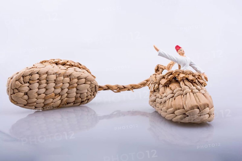 Whirling dervish riding in a straw shoe on a white background
