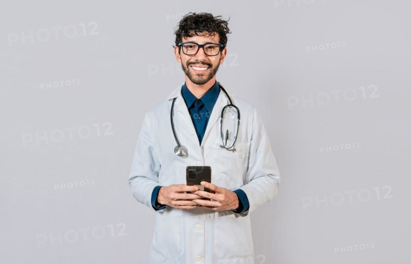 Happy doctor with phone on isolated background. Smiling doctor using cellphone isolated