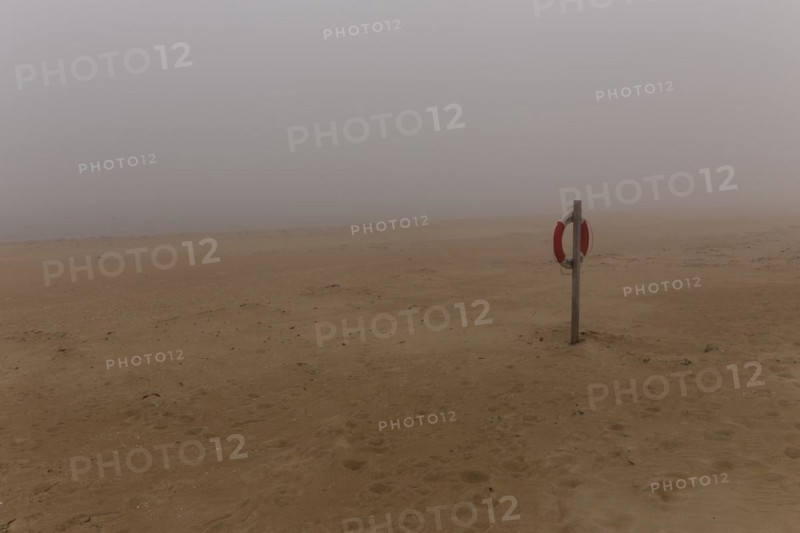 Lifebelt hanging from a post on the beach at Nebel
